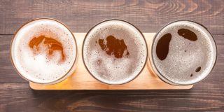 Assortment of beer glasses on a wooden background. Top view