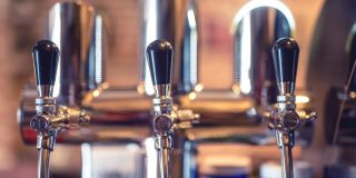Beer tap at restaurant bar or pub. Close-up details of beer draft taps in a row
