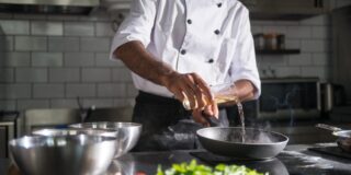 chef pouring oil in pan